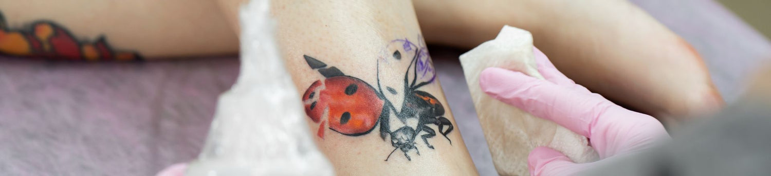 Background is a tablet with a picture of a ladybug in tattoo salon