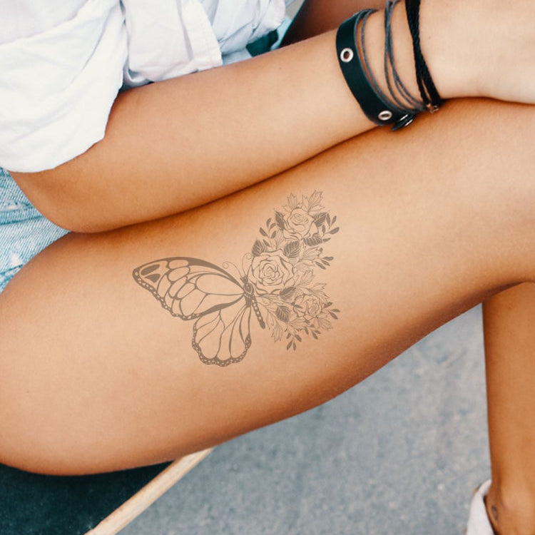 A woman with a butterfly tattoo on her thigh.