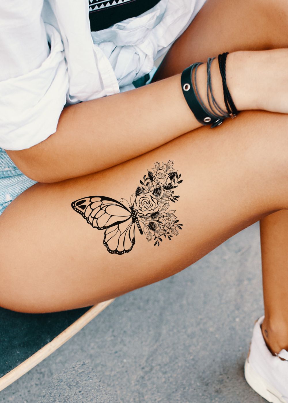 A woman with a butterfly tattoo on her thigh.
