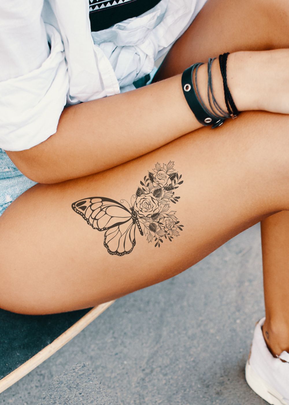 A woman with a butterfly tattoo on her thigh.
