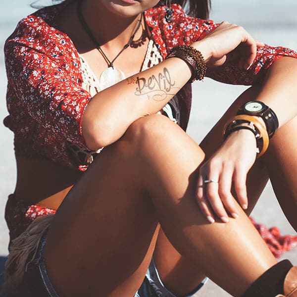 girl with written temporary tattoo on the arm