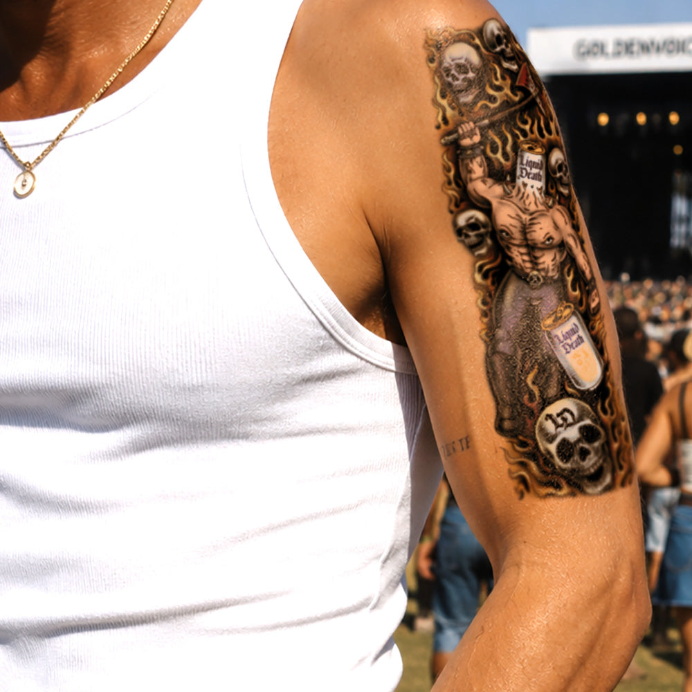 Tattoo on a person's arm with a detailed design, including a figure and text, against a blurred background.