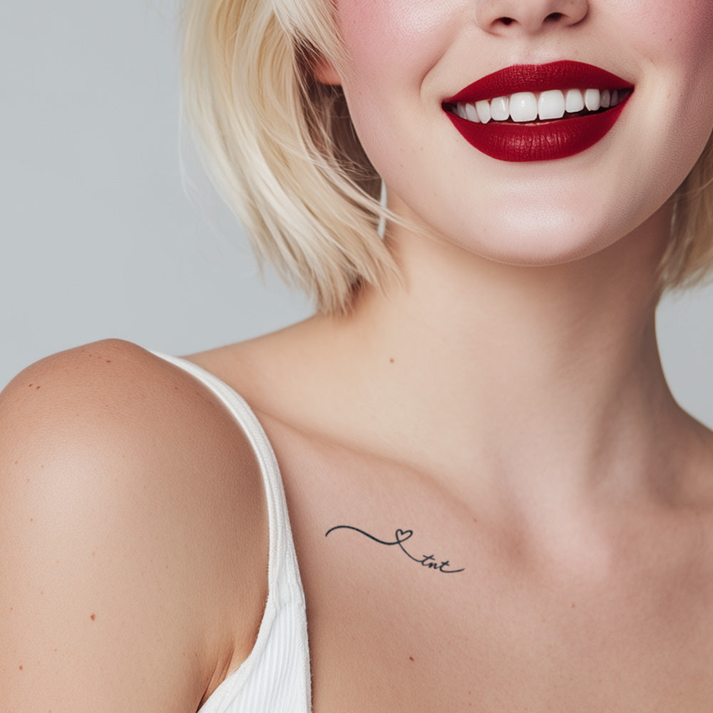 Woman with a small tattoo on her shoulder blade against a plain background