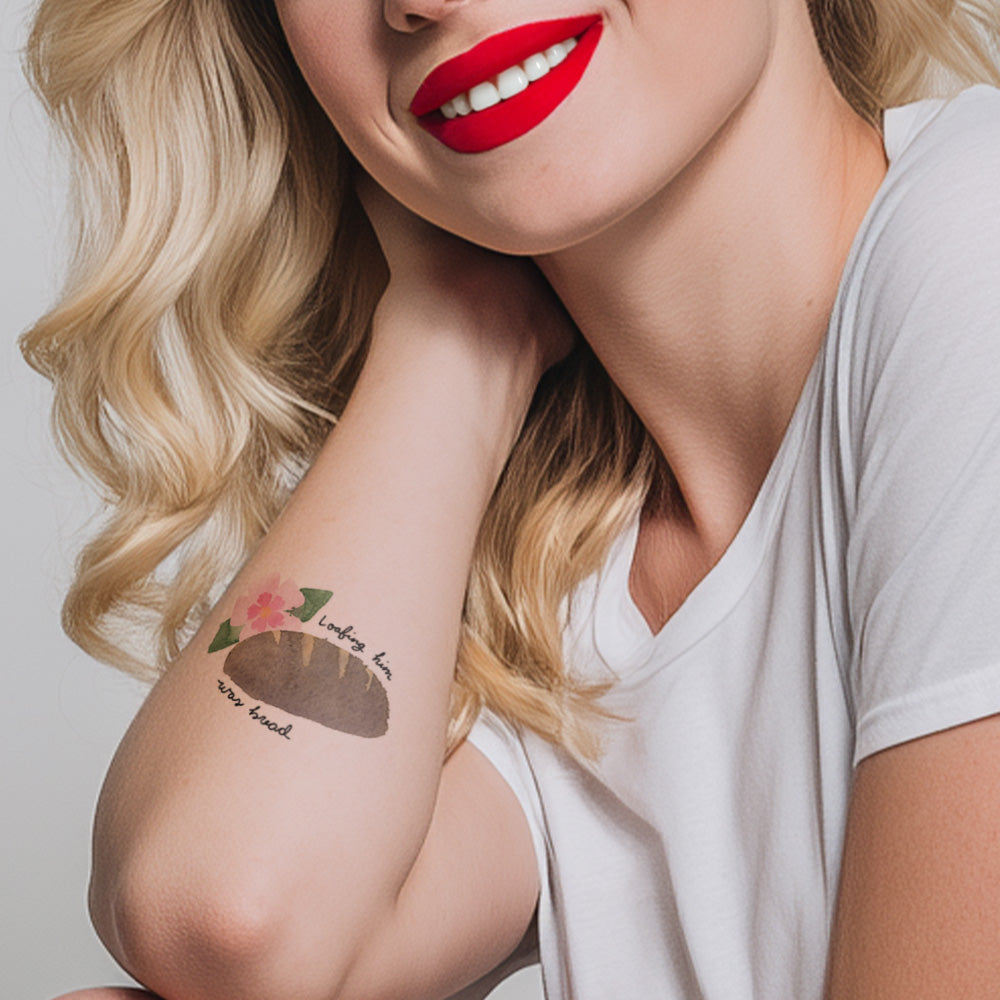 Woman with a tattoo on her arm wearing a white shirt against a plain background