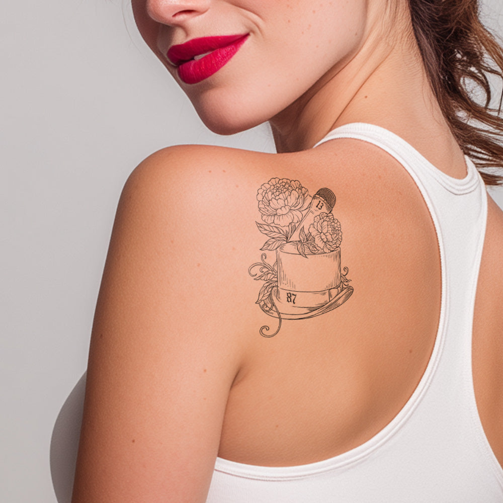 Woman with a tattoo on her shoulder against a plain background