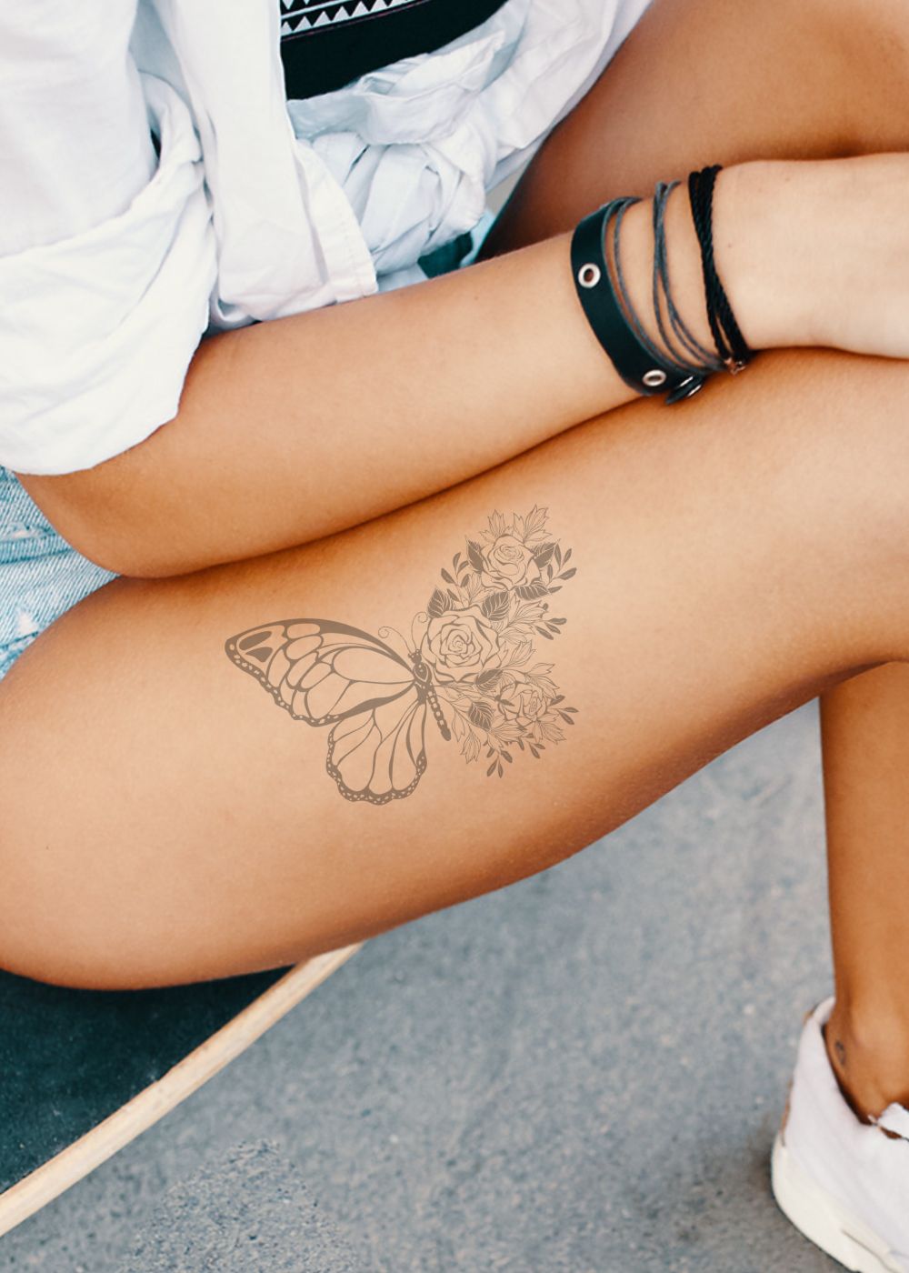 A woman with a butterfly tattoo on her thigh.