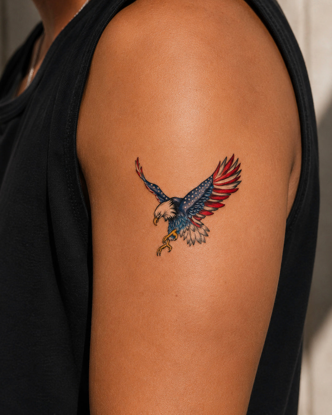 Tattoo of an eagle with a colorful design on a person's arm.
